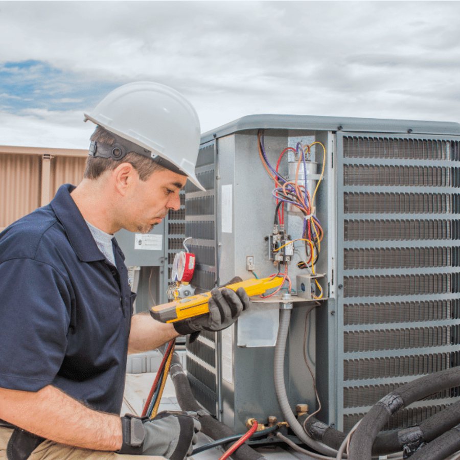 Norfolk Heating & Cooling HVAC technician servicing a system